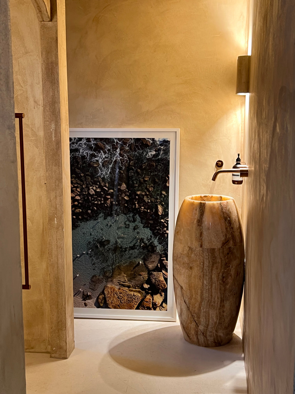 A framed Contemplo print styled beside a stone basin