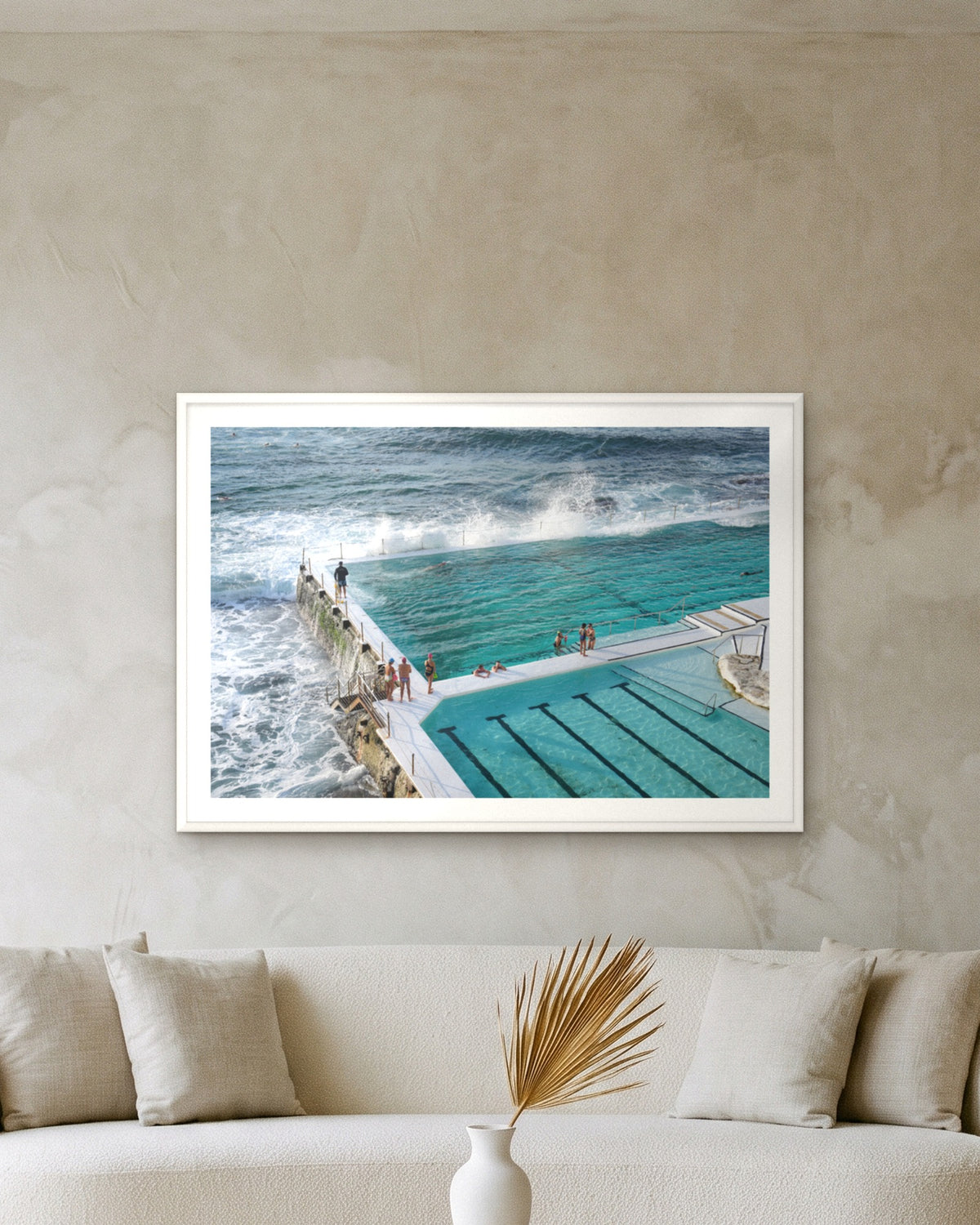 Bondi Swimmers, framed at 83 x 118 cm with a 5 cm white border above a cream boucle sofa