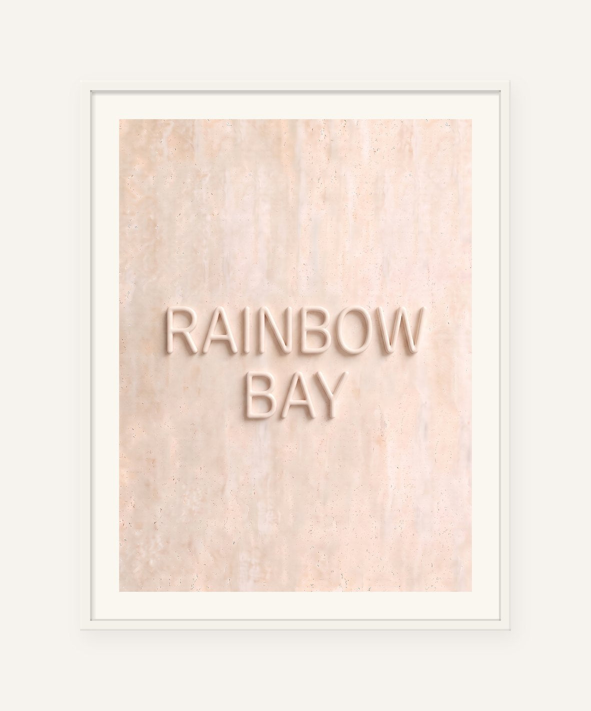 
                  
                    Rainbow Bay, the word carved into soft marble, framed in white with a 5 cm white border
                  
                